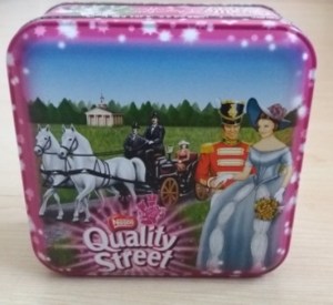 The Quality Street Soldier & Lady against a plantation-style backdrop